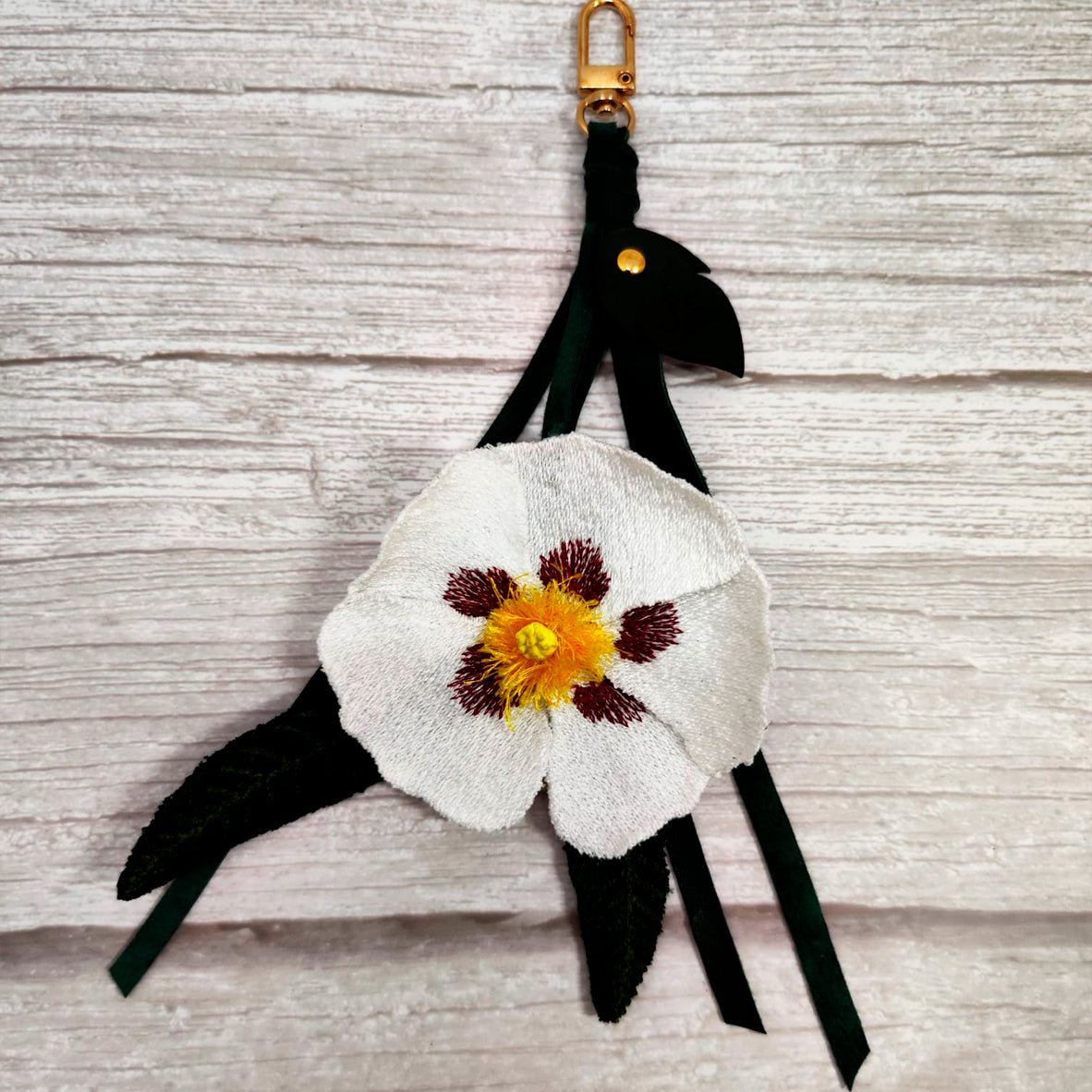 Charm Jara. Flor bordada y cuero natural